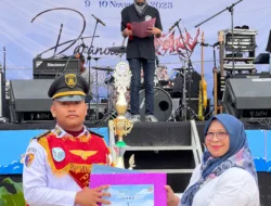 Kepala SMAN 7 Padang menyerahkan Piagam Juara 1 lomba PBB kepada Rehan Danton (Komandan Pasukan) PBB SMA Praja.